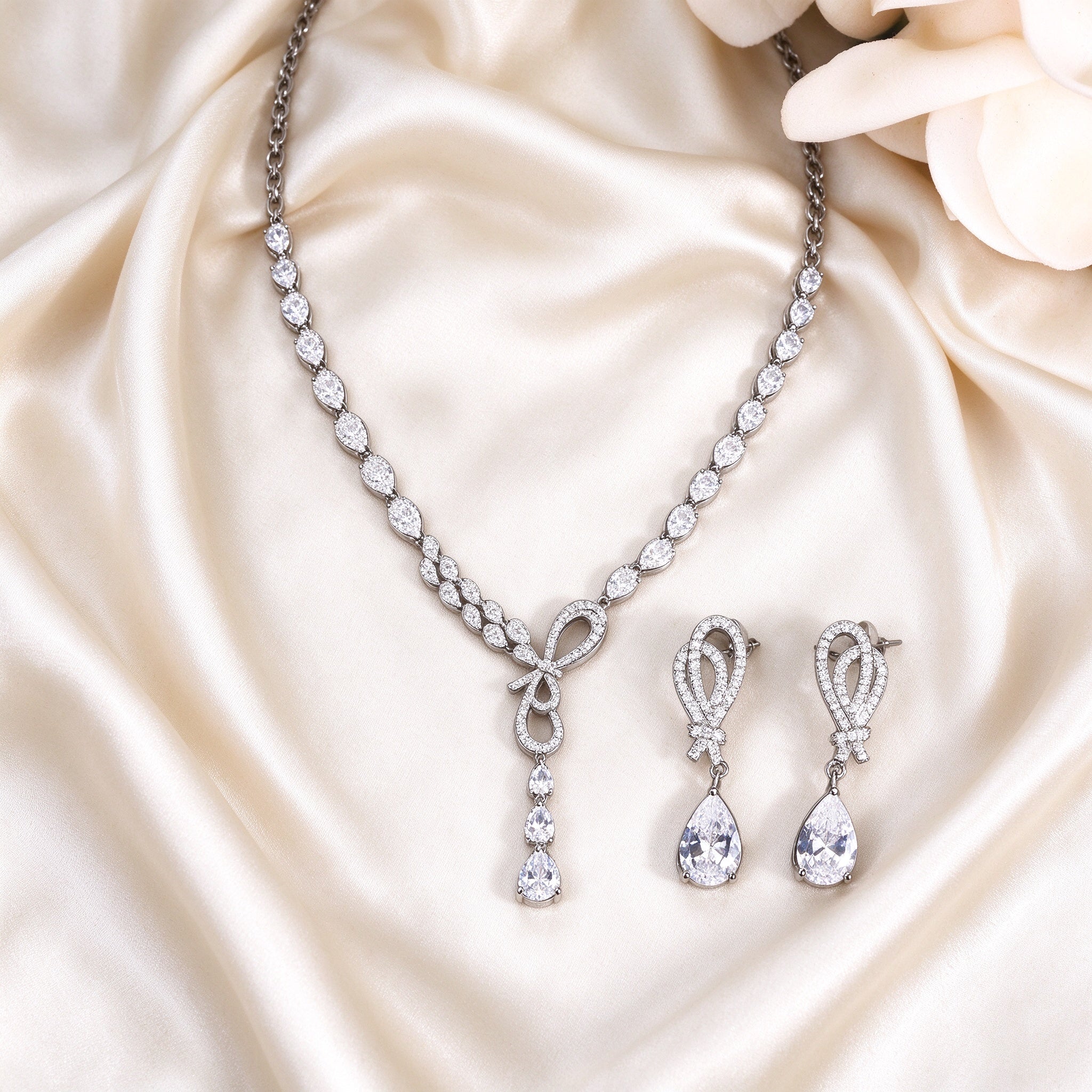 The Cameron Bridal Set – necklace and matching earrings laid flat on cream silk satin