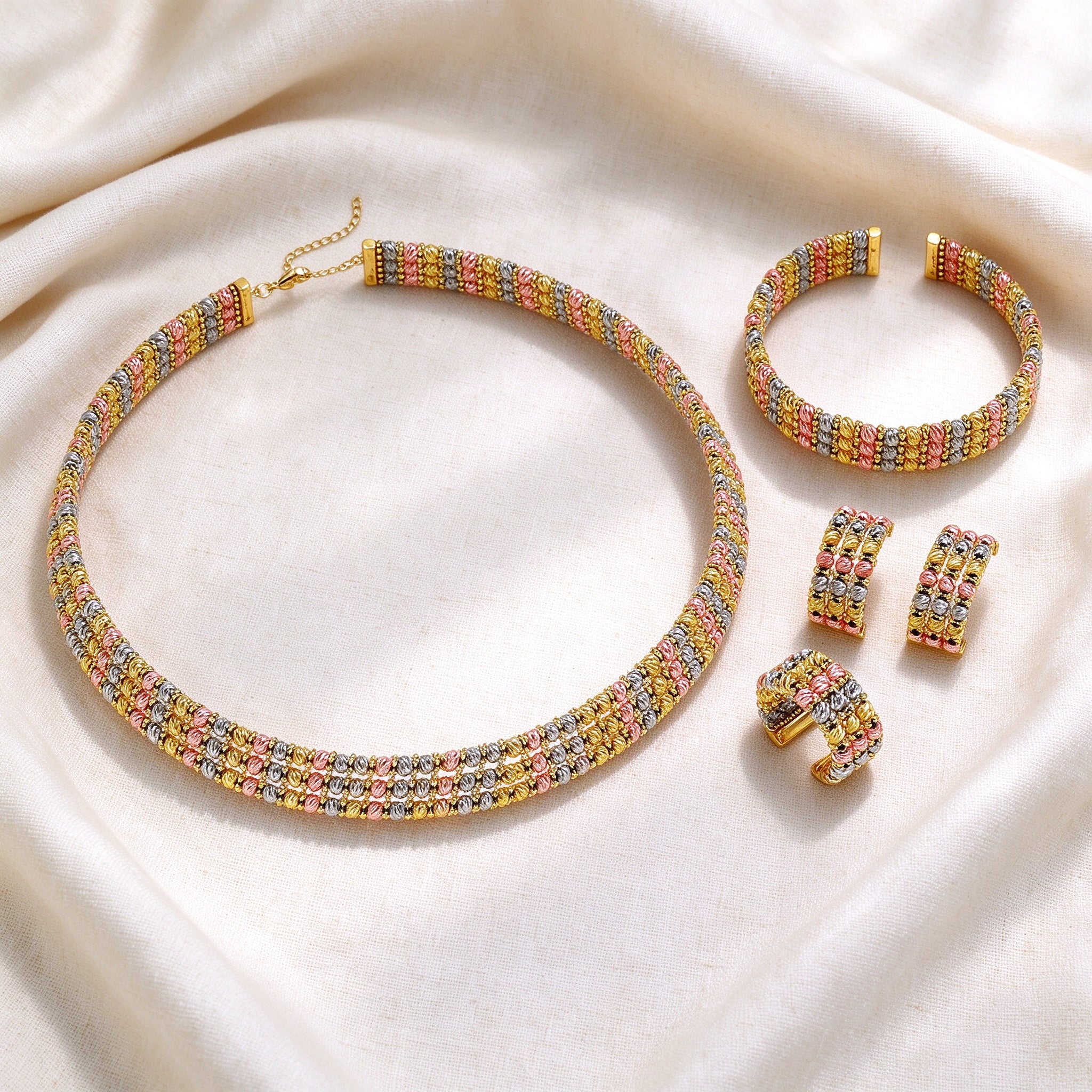 Flat lay of The Emerson Wedding Suite necklace, bangle, earrings and ring on ivory linen