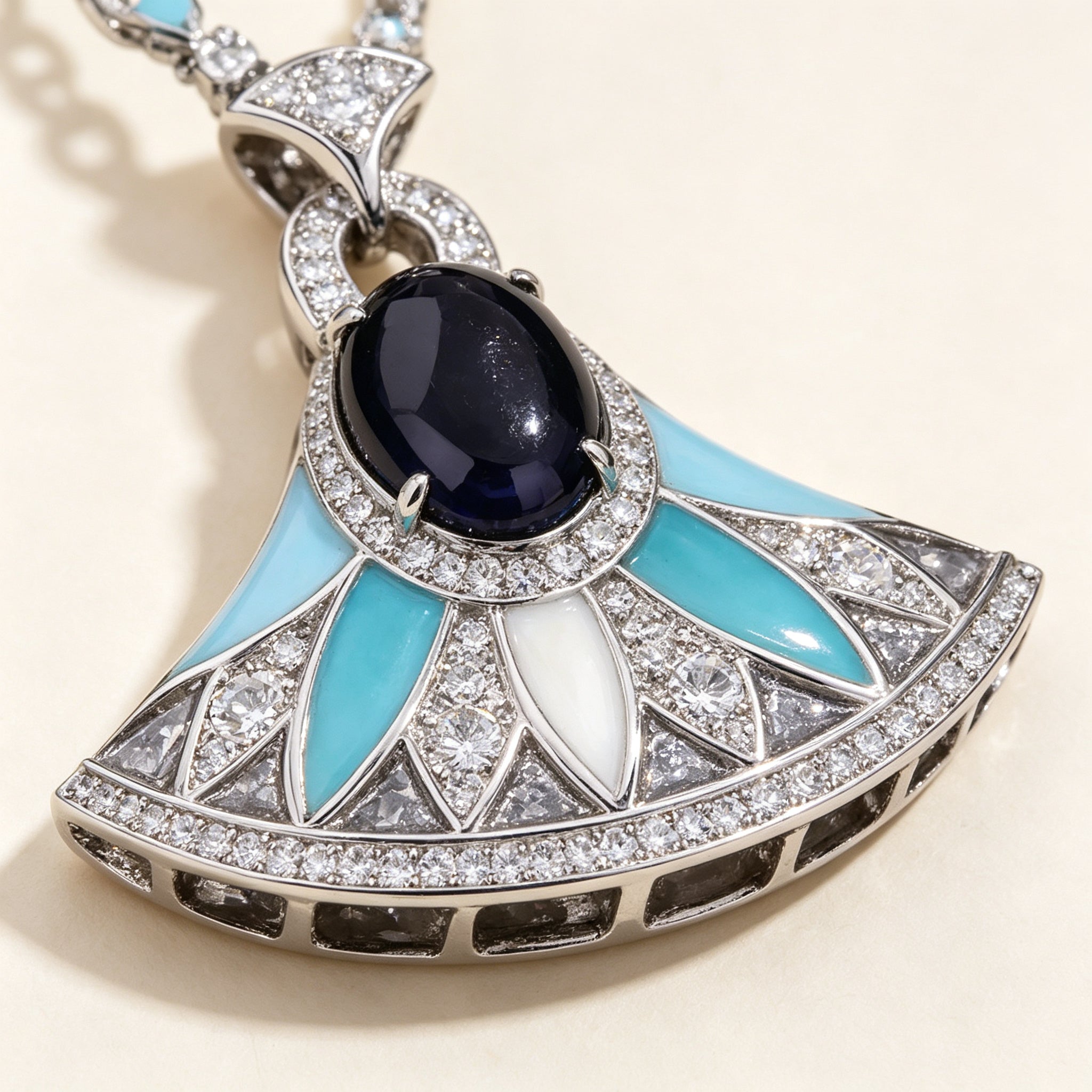 Macro close-up of the navy cabochon center and turquoise enamel fan blades edged in cubic zirconia