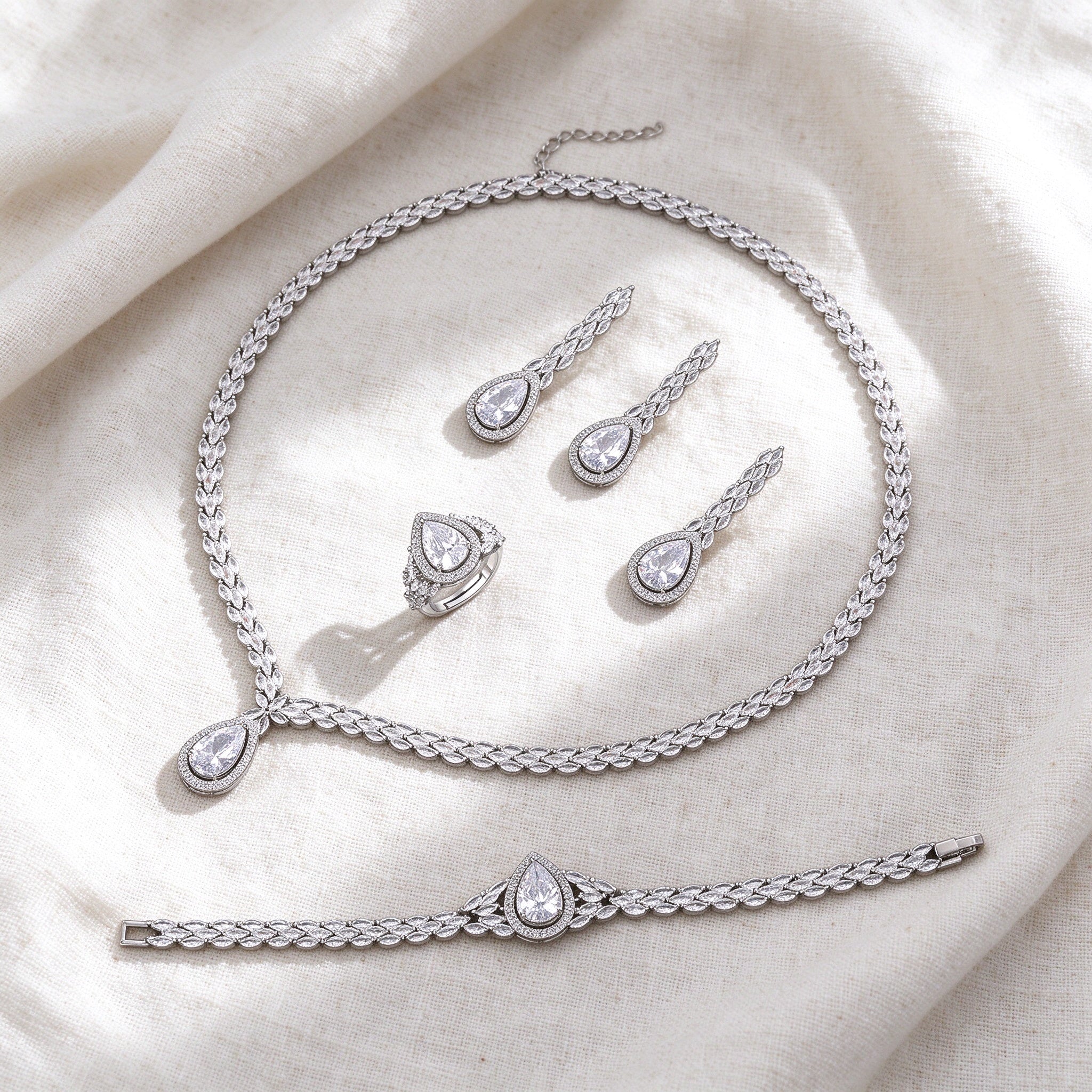 Silver-tone Fern bridal jewelry set flat lay on ivory linen