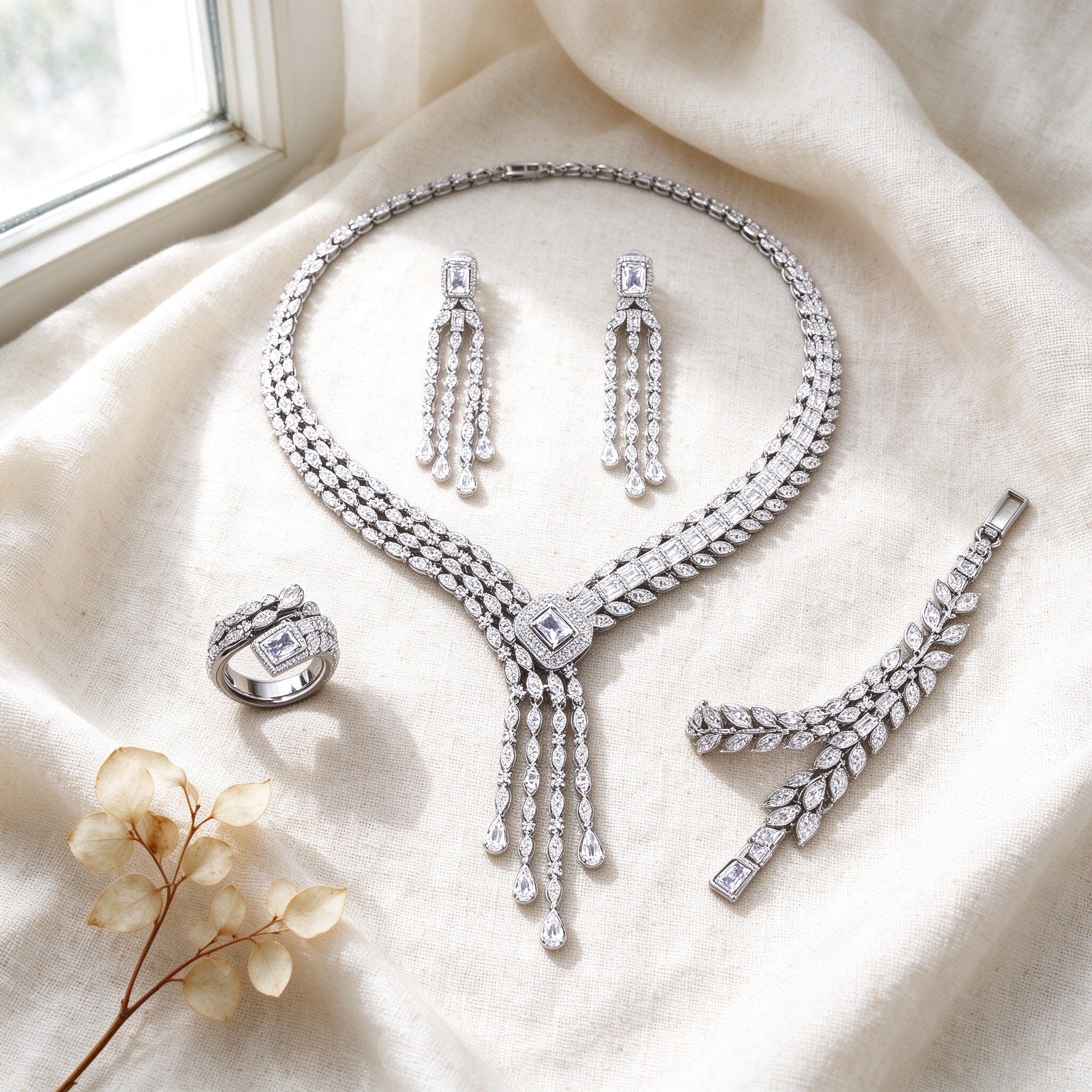 Top-down flat lay of The Harvest Bridal Parure four-piece silver CZ bridal set on ivory linen