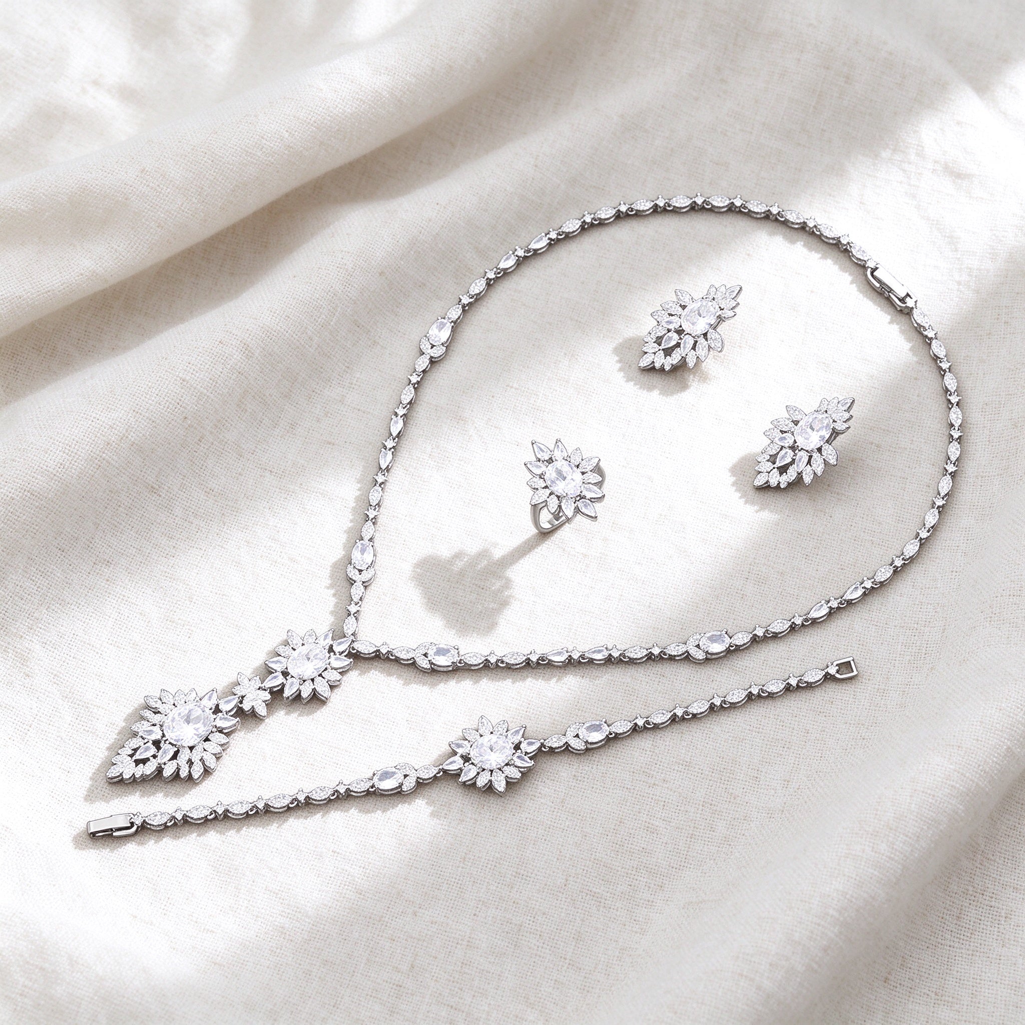 Silver-tone Iris bridal jewelry set flat lay on ivory linen