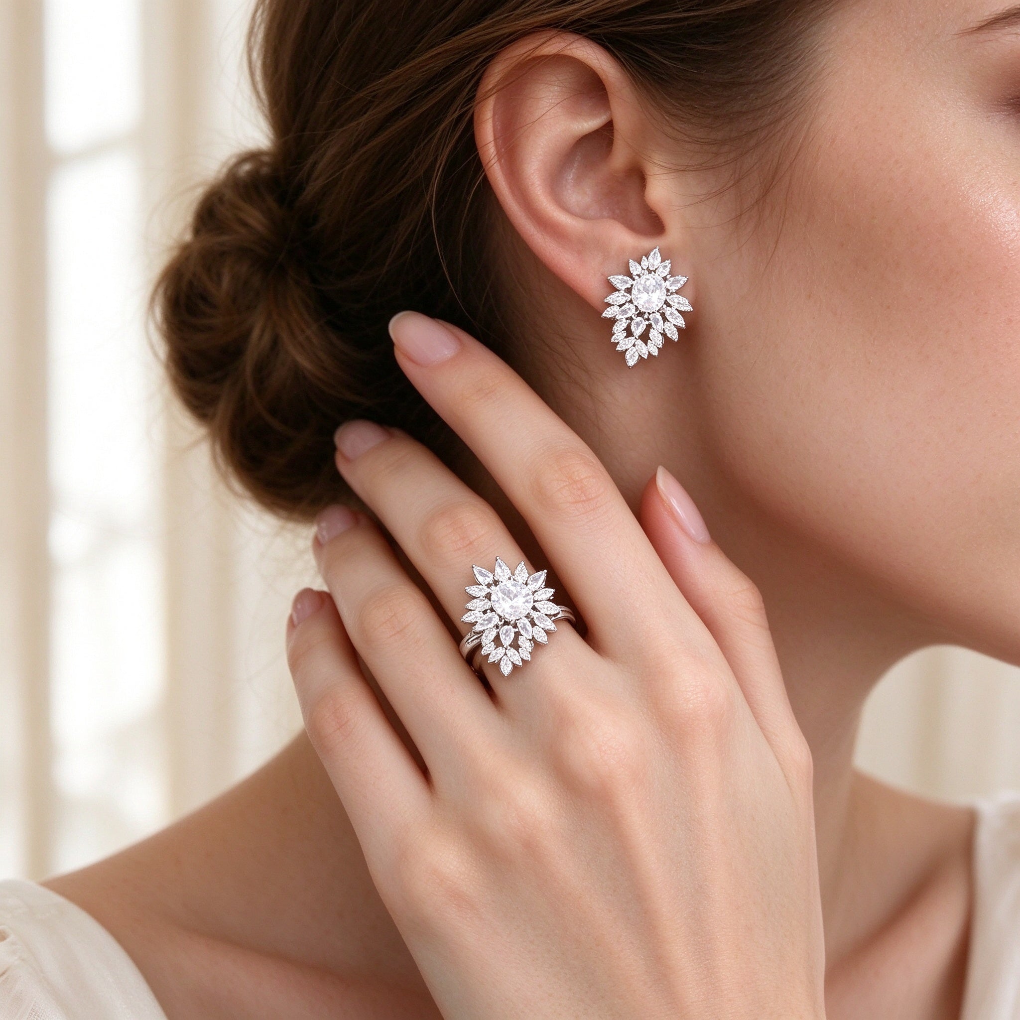 Close-up of floral sunburst cluster CZ stud earrings and ring