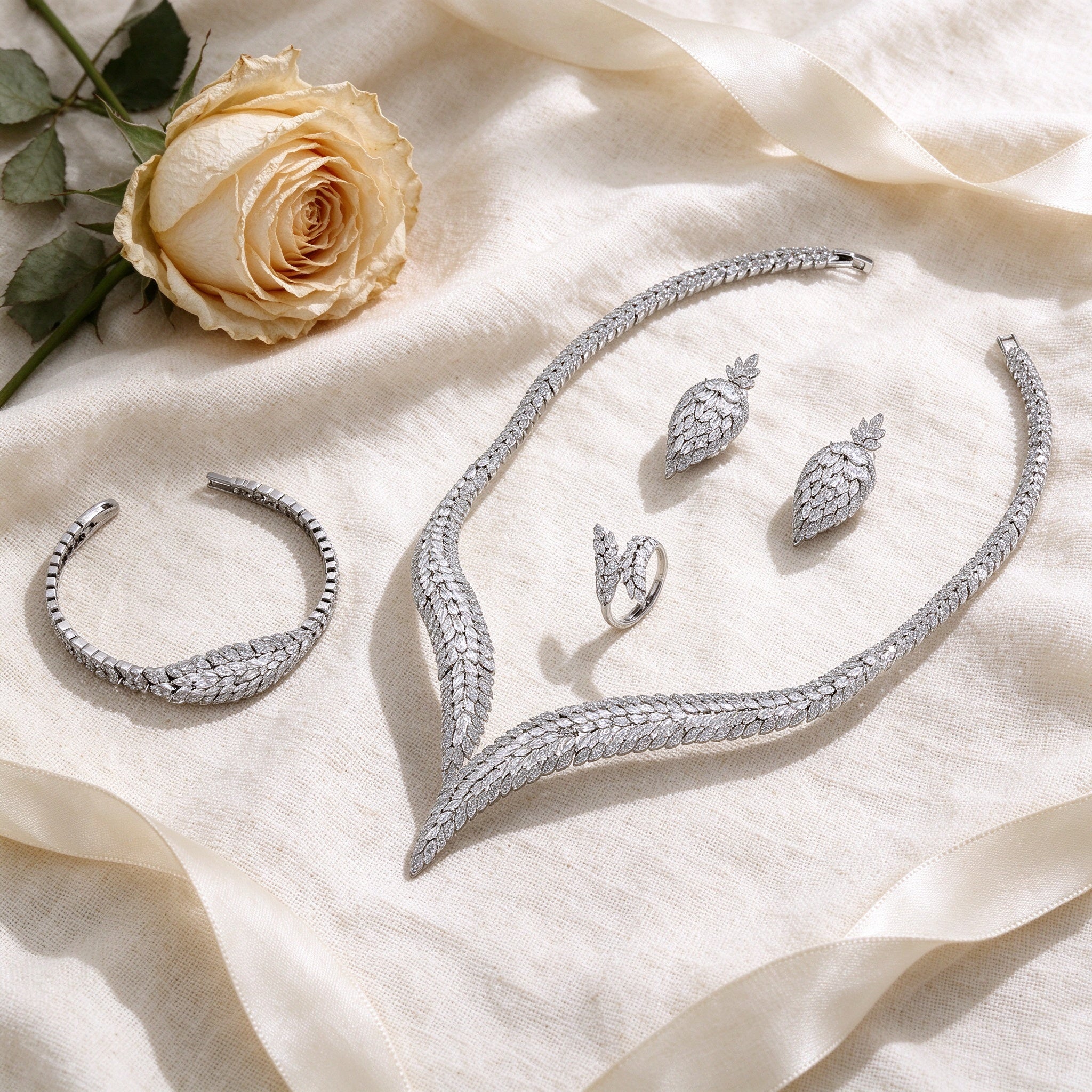 Flat lay of The Midnight Bridal Set on cream linen with dried rose