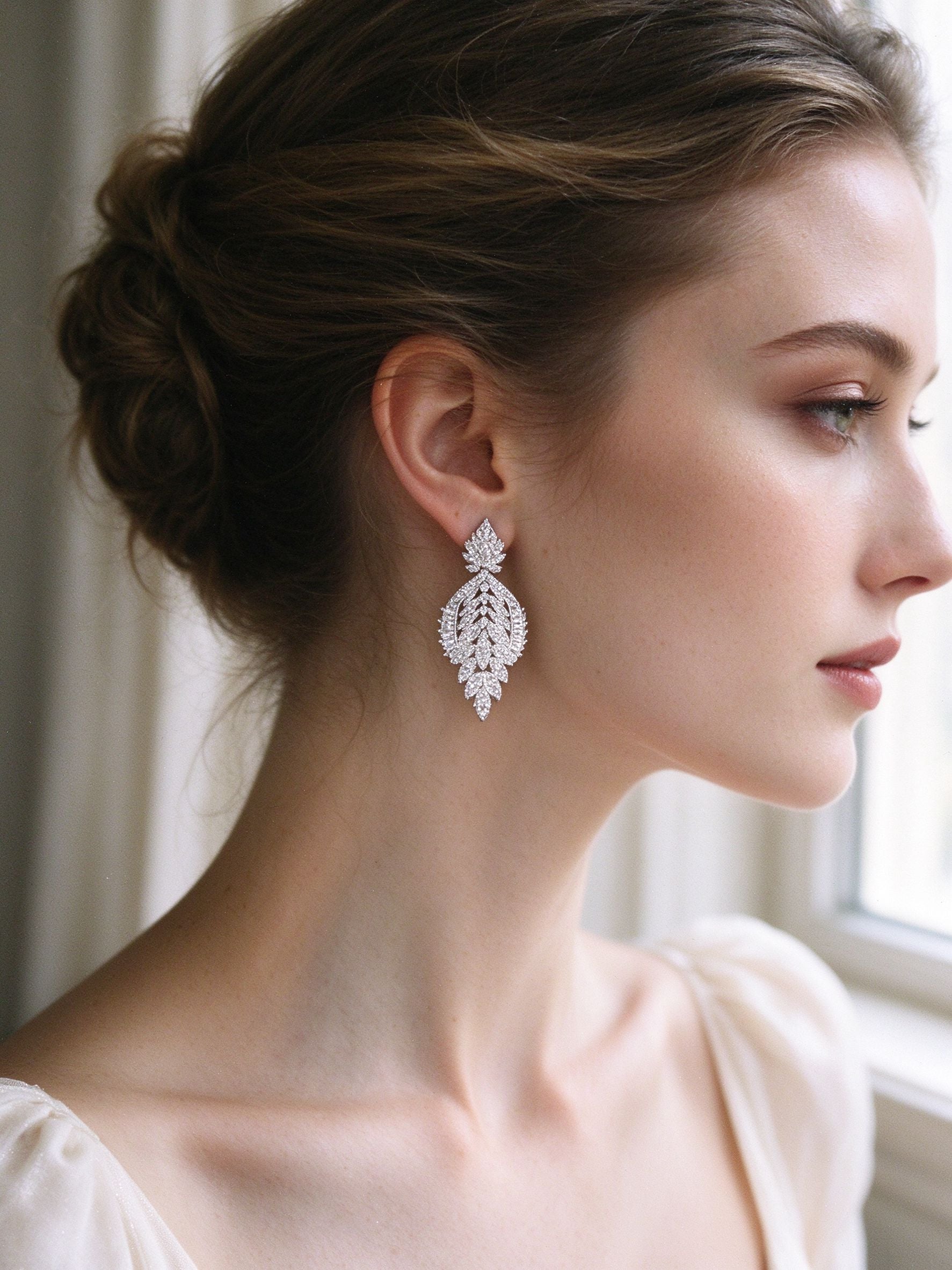 Close-up of bride wearing The Petal Bridal Set micro-pavé teardrop leaf earrings