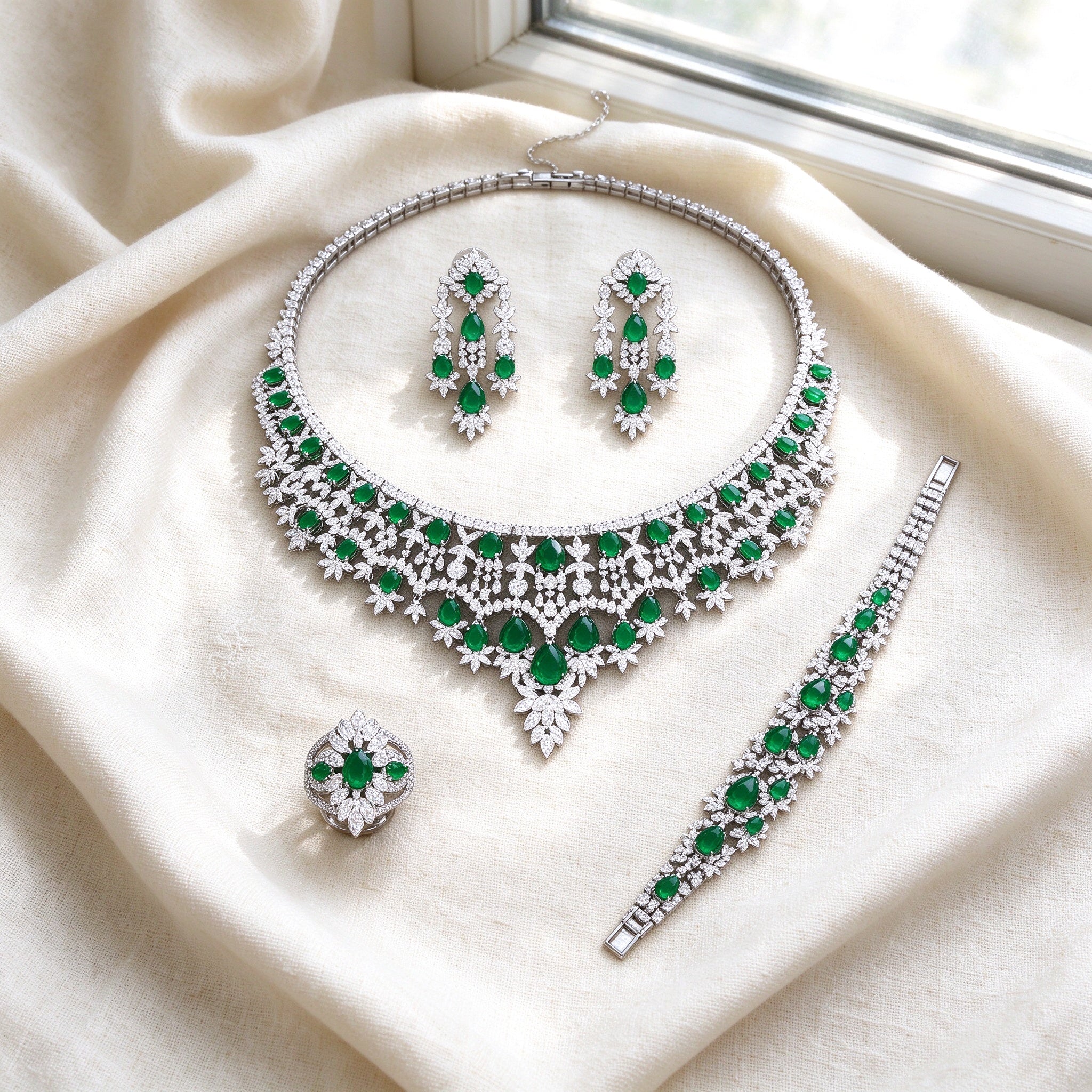 Flat lay of The Rain Crystal Parure on ivory linen — necklace, earrings, bracelet, ring