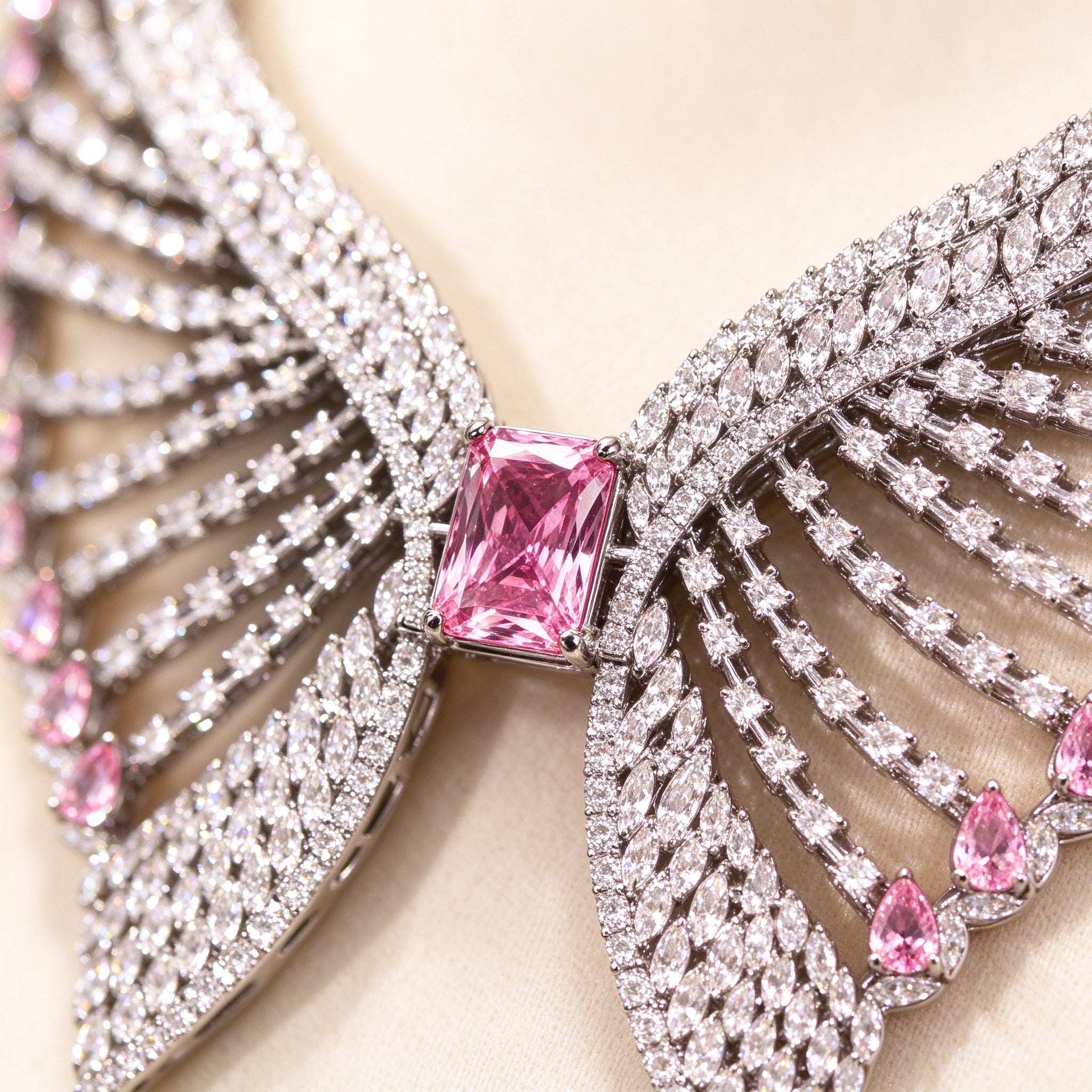Macro close-up of a pink emerald-cut cubic zirconia surrounded by radiating clear CZ feathered rows