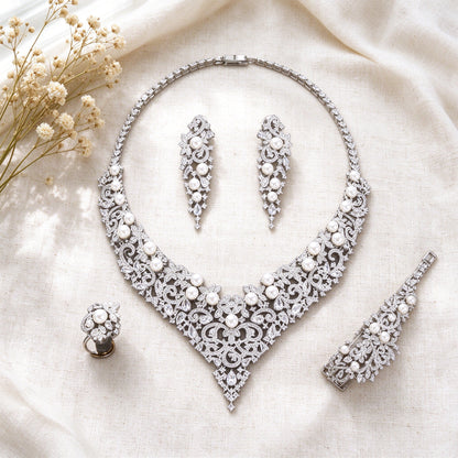 Overhead flat lay of The Grain Bridal Set necklace, earrings, bracelet and ring on ivory linen