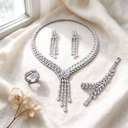 Top-down flat lay of The Harvest Bridal Parure four-piece silver CZ bridal set on ivory linen
