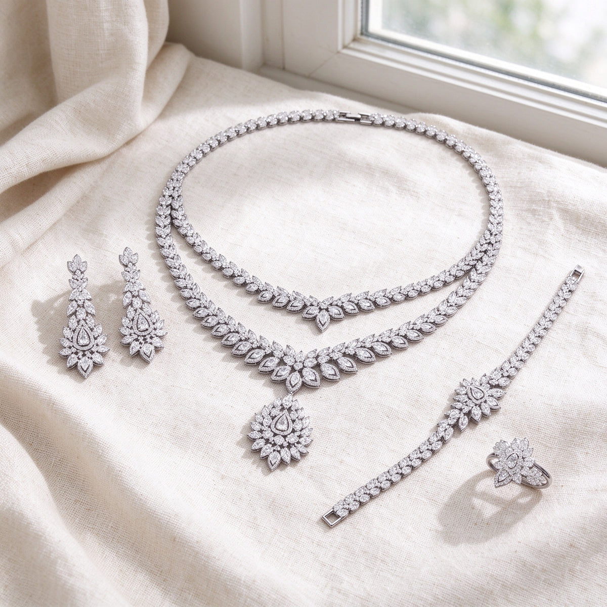 Flat lay of complete Clementine bridal set on warm ivory linen