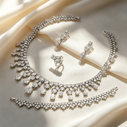 Top-down flat lay of The Lily Wedding Suite necklace, earrings, bracelet and ring
