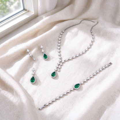 Overhead flat lay of The Magnolia Crystal Parure three pieces on soft ivory linen by a bright window