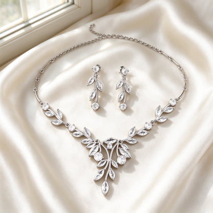 Flat lay of The Delaney Wedding Suite two-piece necklace and earrings on ivory silk satin