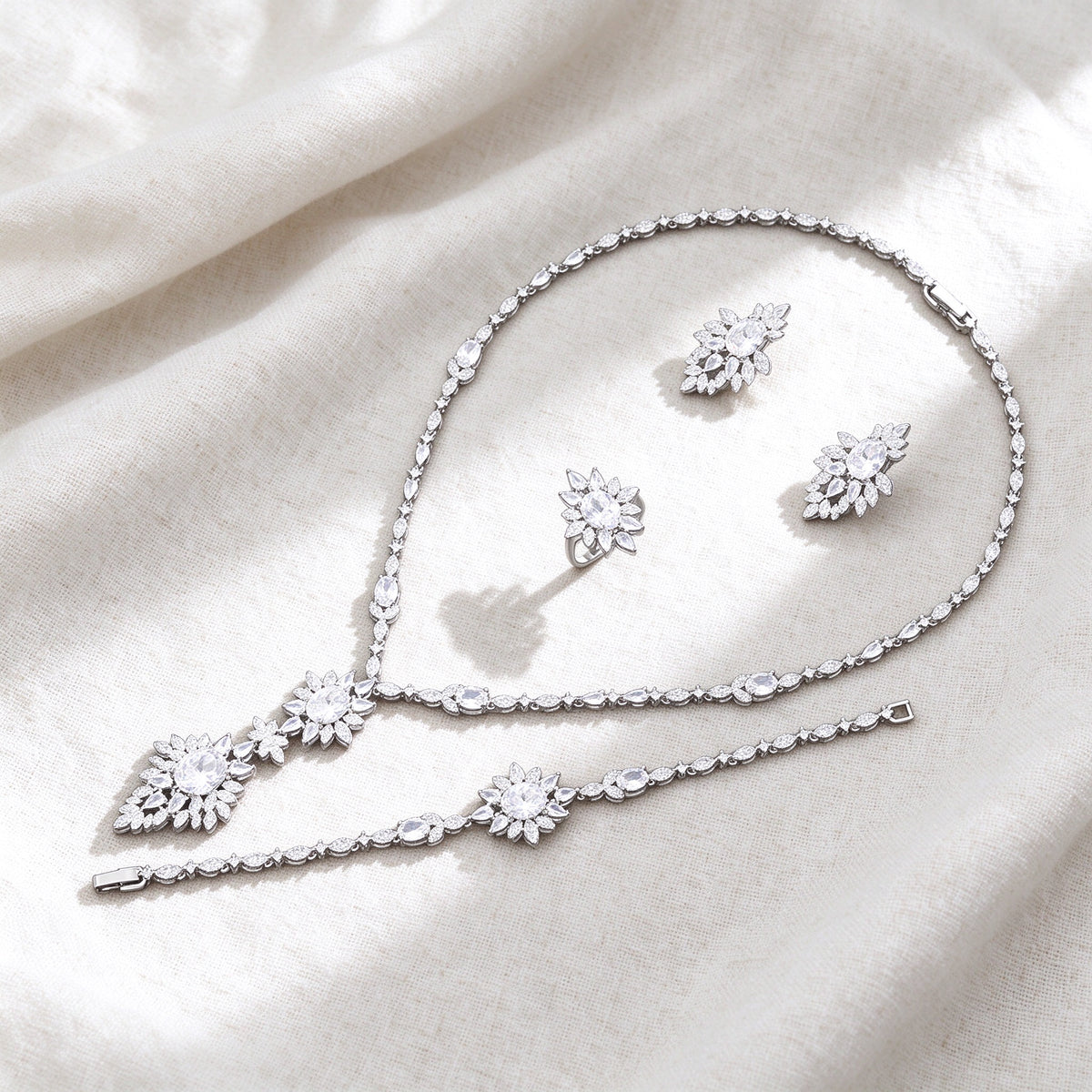 Silver-tone Iris bridal jewelry set flat lay on ivory linen