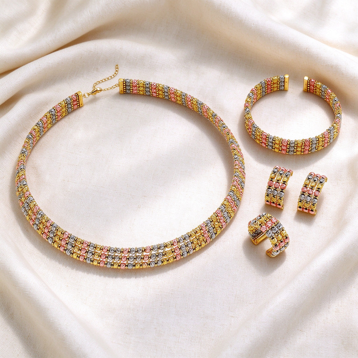 Flat lay of The Emerson Wedding Suite necklace, bangle, earrings and ring on ivory linen