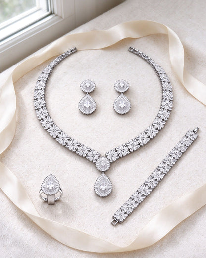 The Root Wedding Suite necklace, earrings, bracelet and ring flat-laid on ivory linen