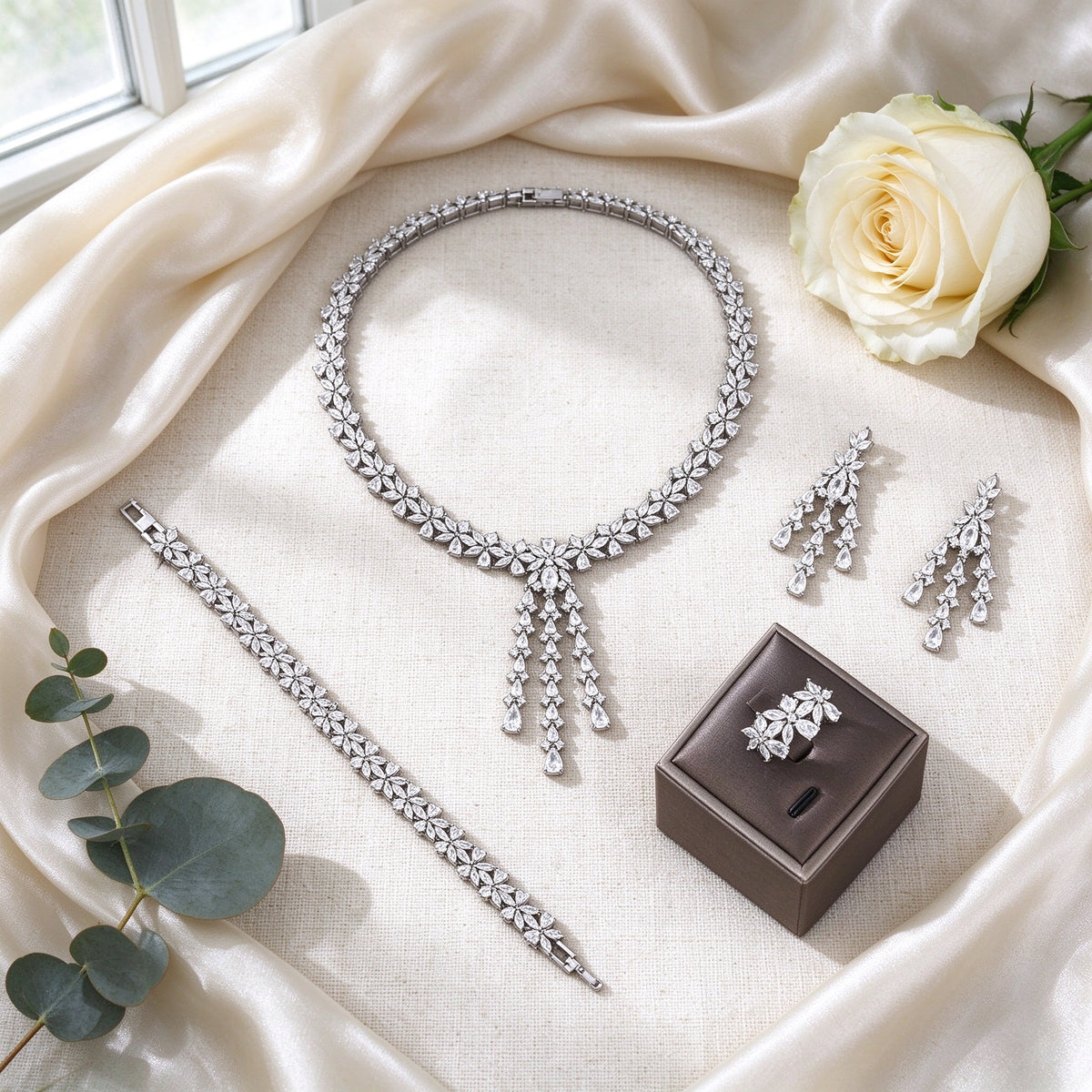 Flat lay of The Meadow Wedding Suite four-piece bridal set on ivory silk