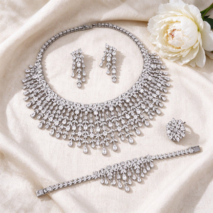 Flat lay of The Comet Crystal Parure four-piece bridal jewelry set on ivory linen