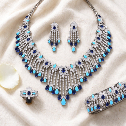 Flat lay of The Celestine Bridal Parure necklace, earrings, bracelet and ring on linen