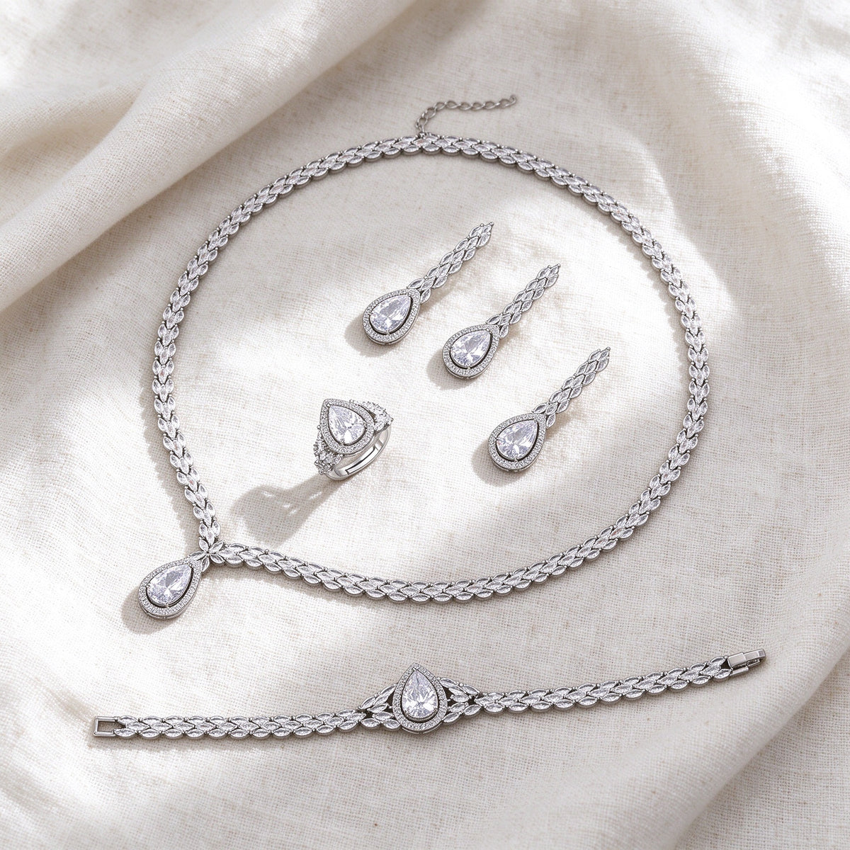 Silver-tone Fern bridal jewelry set flat lay on ivory linen
