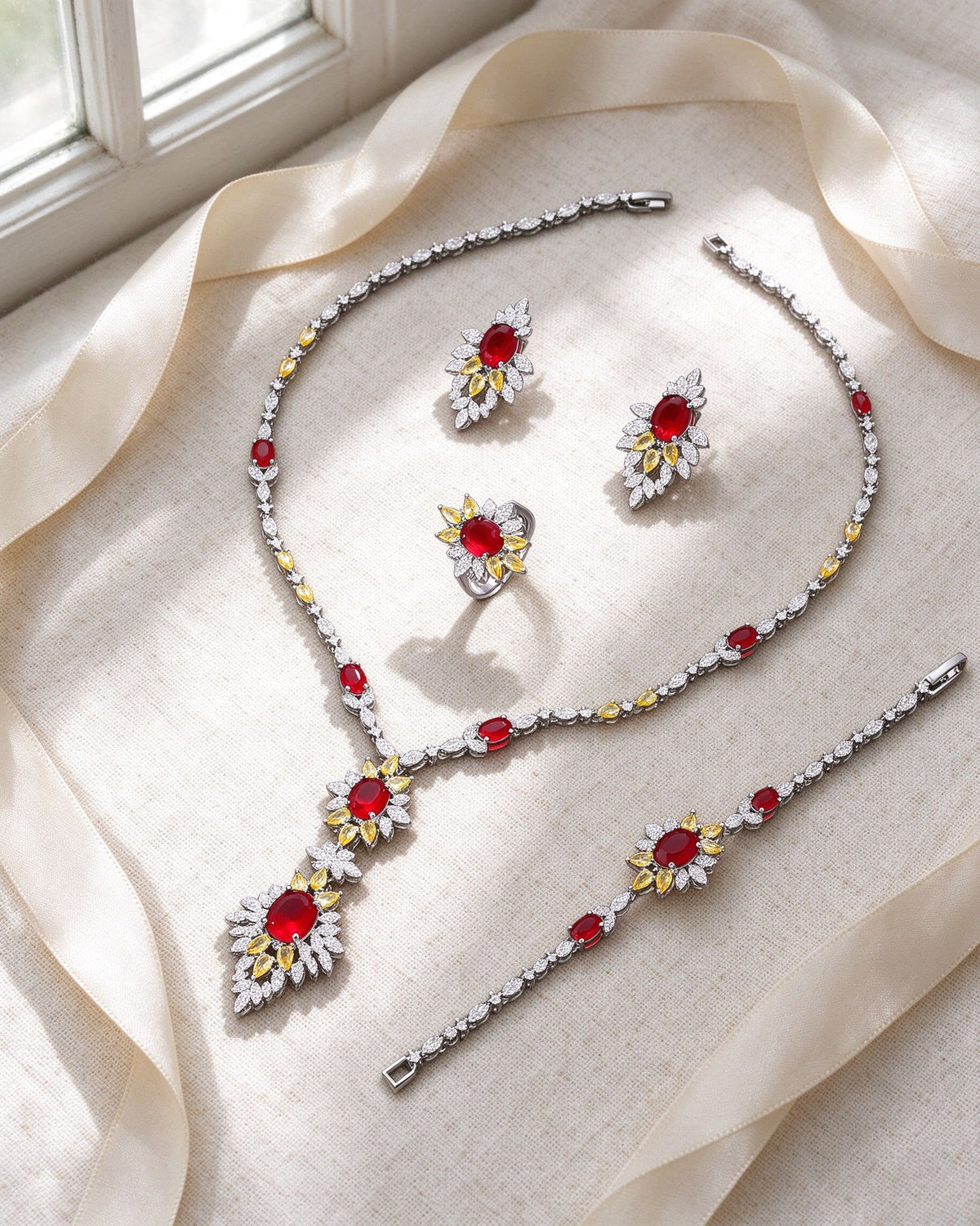 The Seed Bridal Parure necklace, earrings, bracelet and ring flat-laid on ivory linen
