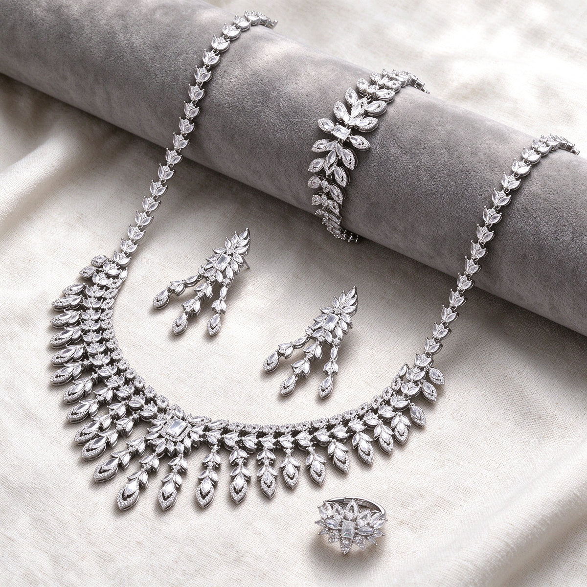 Silver-tone Eve bridal jewelry set flat lay on ivory linen