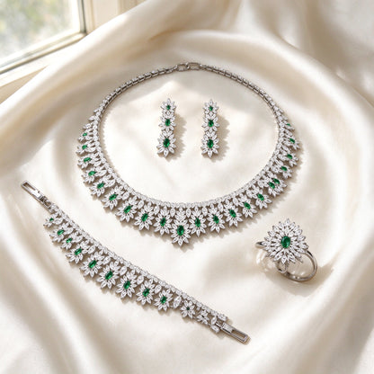 Flat lay of The Kennedy Crystal Parure four-piece floral sunburst set on ivory silk satin