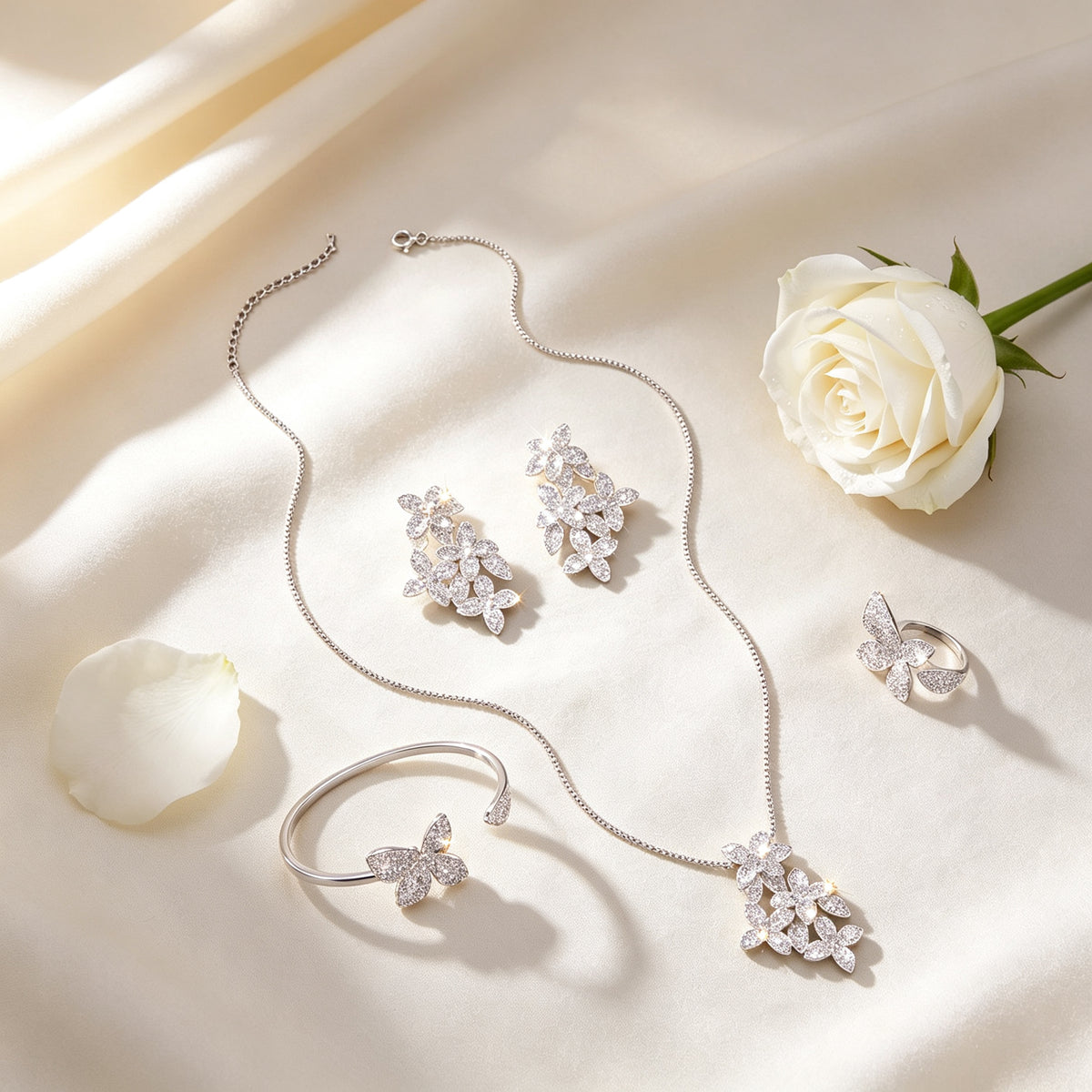 Flat lay of The Cosmo Bridal Parure necklace, earrings, bangle and ring on ivory linen
