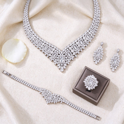 Top-down flat lay of The Diadem Bridal Parure four-piece clear CZ bridal set on ivory linen