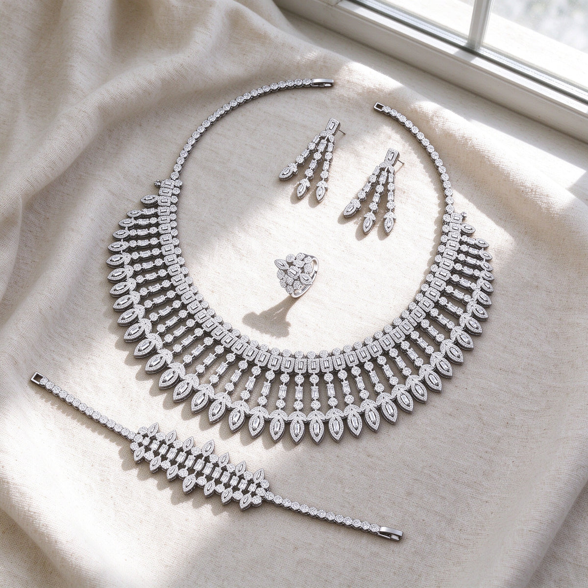 Overhead flat lay of The Jasmine Bridal Set four pieces on soft ivory linen by a bright window