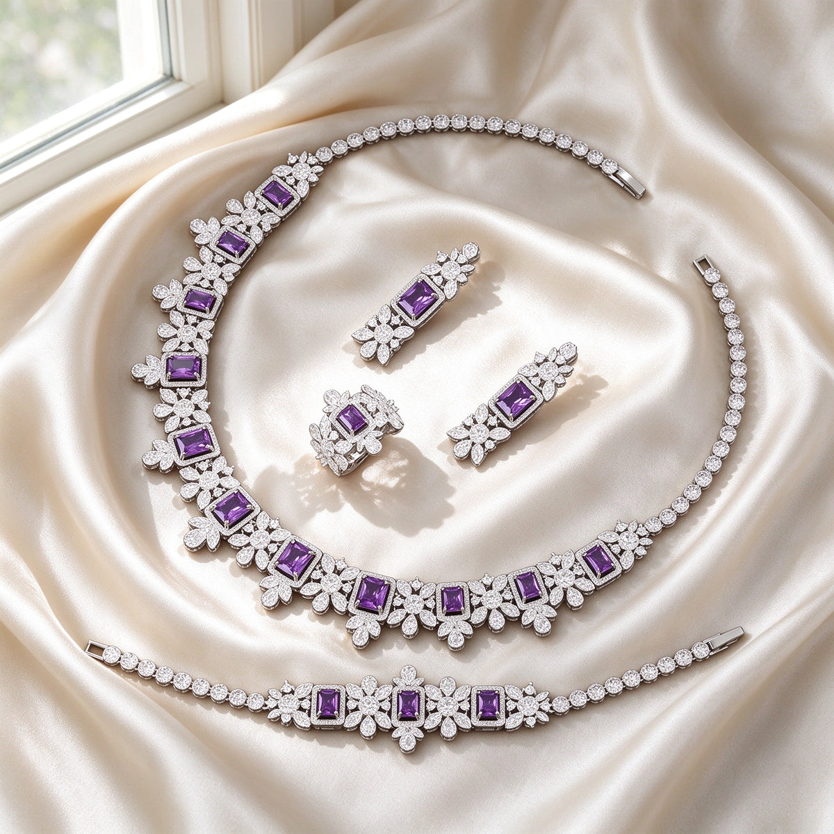 Flat lay of The Arabella Bridal Parure four-piece set on ivory silk satin