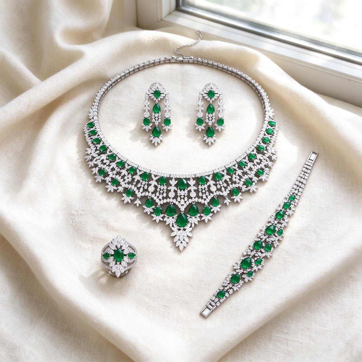Flat lay of The Rain Crystal Parure on ivory linen — necklace, earrings, bracelet, ring
