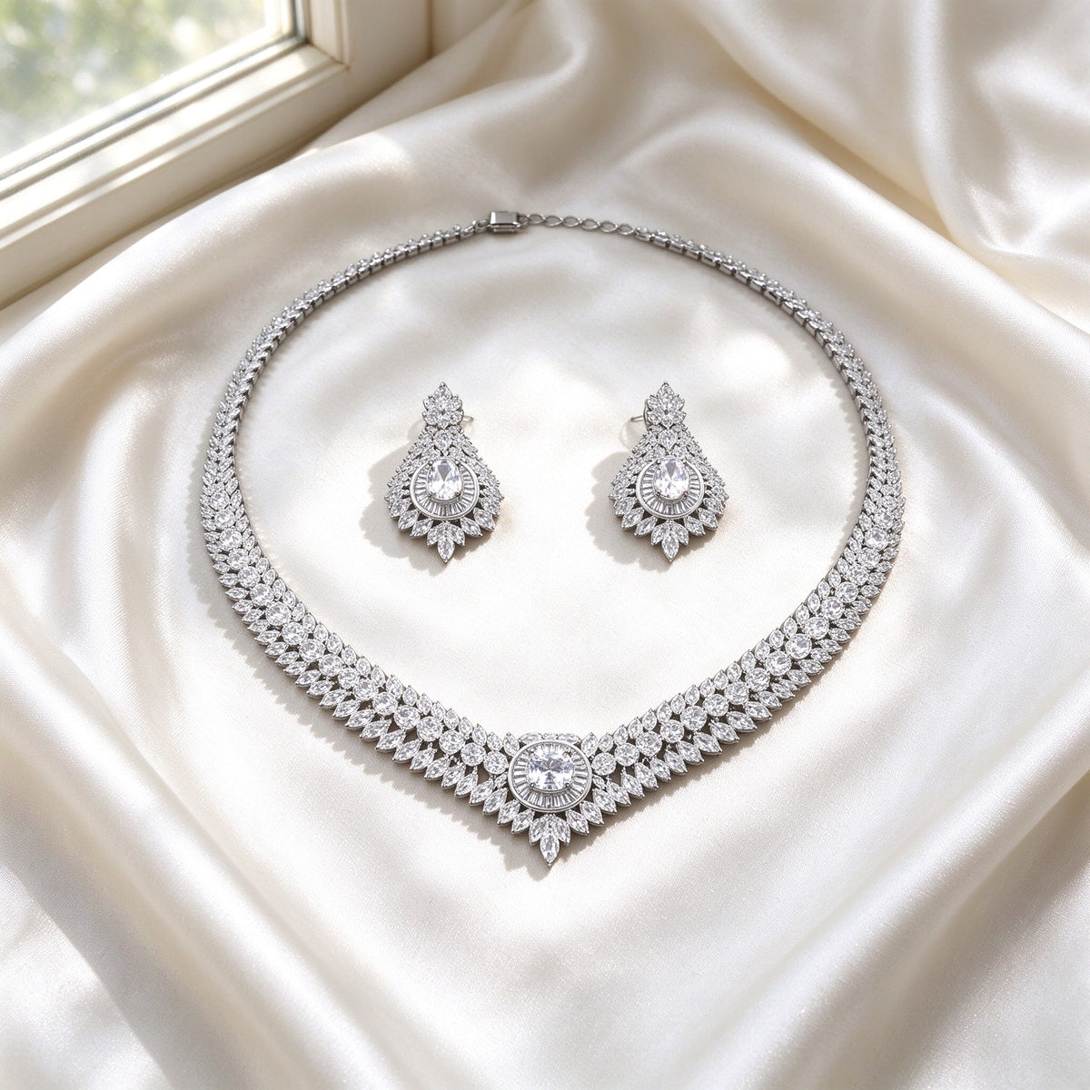 Flat lay of The Sutton Bridal Parure two-piece necklace and earrings on ivory silk satin