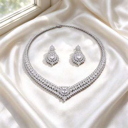 Flat lay of The Sutton Bridal Parure two-piece necklace and earrings on ivory silk satin