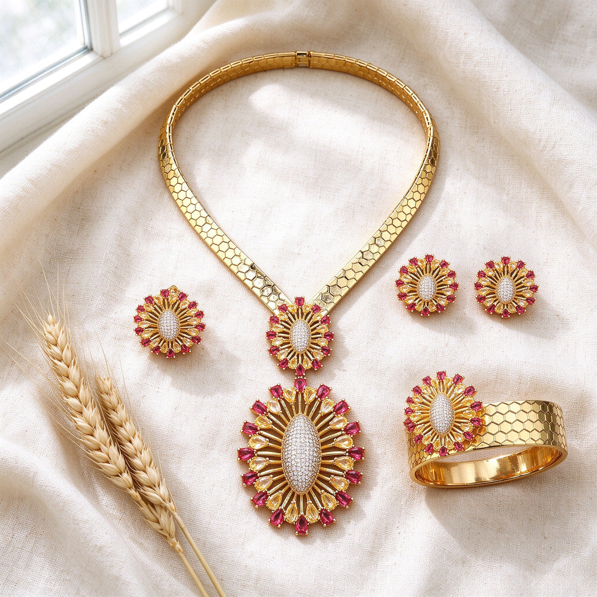 Top-down flat lay of The Solstice Bridal Set four-piece gold sunburst bridal set on ivory linen with wheat