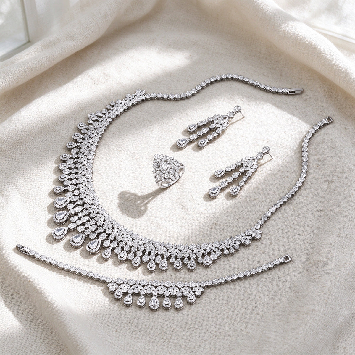 Top-down flat lay of The Moonlight Bridal Set four-piece silver pavé bridal set on warm ivory linen