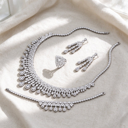 Top-down flat lay of The Moonlight Bridal Set four-piece silver pavé bridal set on warm ivory linen
