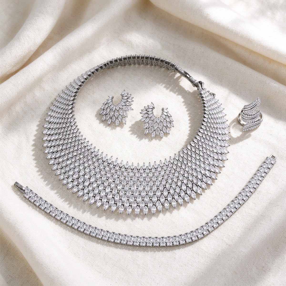 Flat lay of The Skye Bridal Set on ivory linen — necklace, earrings, bracelet, ring