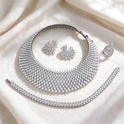 Flat lay of The Skye Bridal Set on ivory linen — necklace, earrings, bracelet, ring