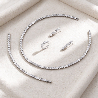 Overhead flat lay of The Thorn Wedding Suite four pieces on warm cream linen