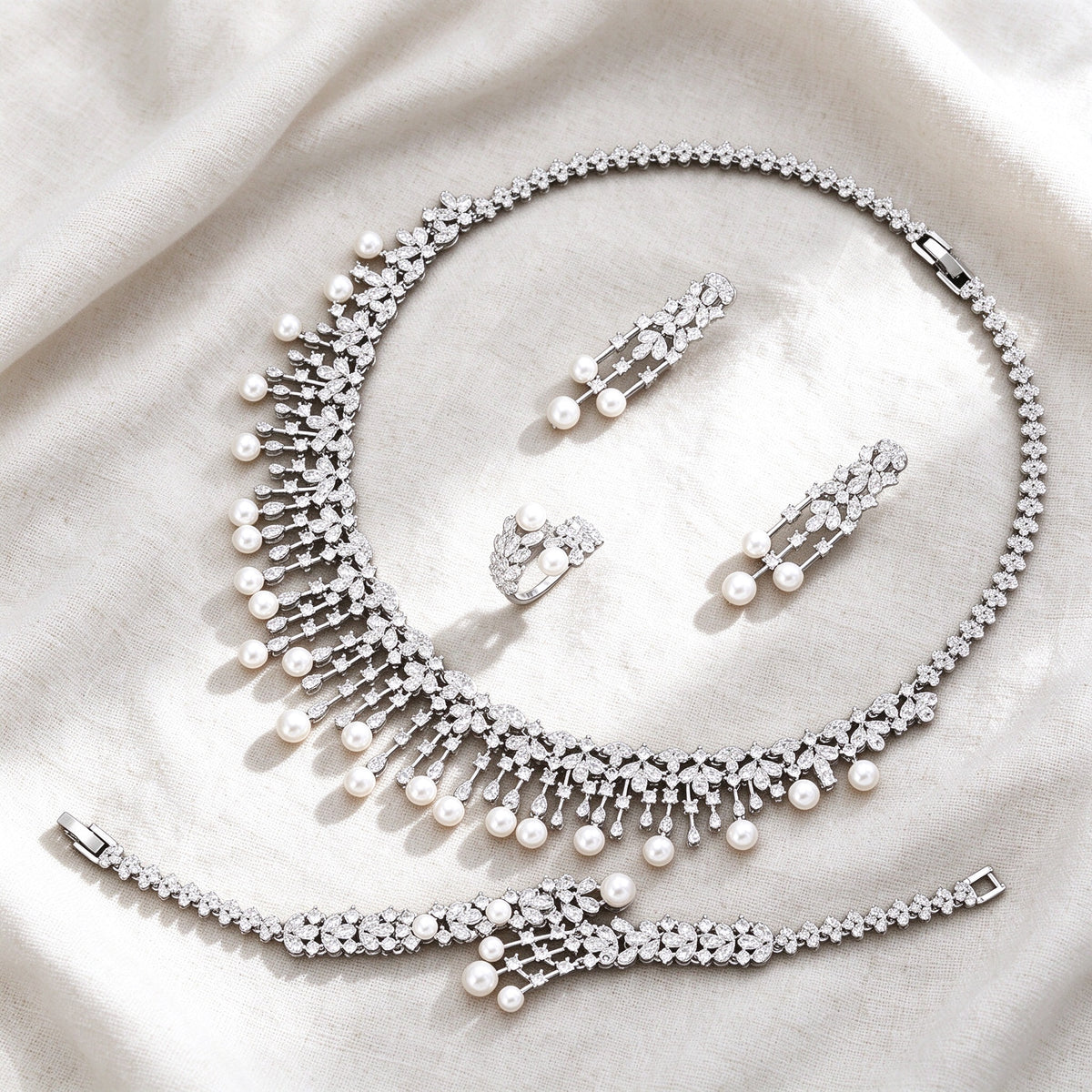 Silver-tone Rue bridal pearl jewelry set flat lay on ivory linen