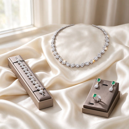 The Celestia Wedding Suite silver-tone alternating emerald and pear cut halo CZ necklace, bracelet, drop earrings and bypass ring on ivory silk