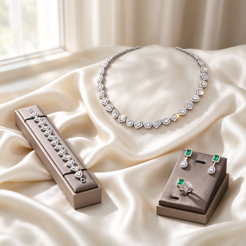 The Celestia Wedding Suite silver-tone alternating emerald and pear cut halo CZ necklace, bracelet, drop earrings and bypass ring on ivory silk