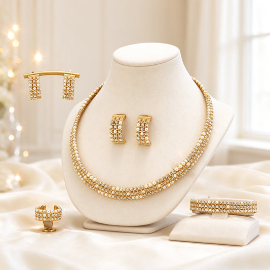 The Isolde Bridal Set — gold-tone woven micro-pavé collar necklace with cream pearl beads, bar-drop earrings, bracelet and open ring on an ivory background