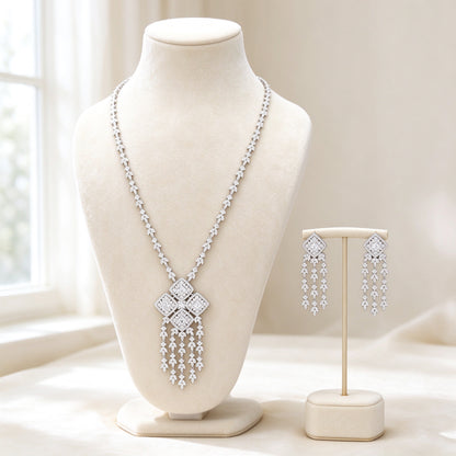 The Aster Bridal Set — silver-tone cubic zirconia Y-necklace with four-quad tassel pendant and matching drop earrings on ivory velvet bust