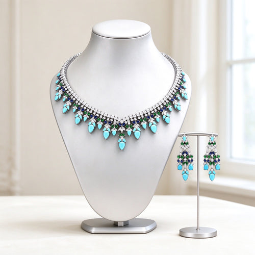 The Sloane Bridal Set — silver-tone graduated fringe bib necklace with turquoise pear CZ drops and matching chandelier earrings on an ivory background