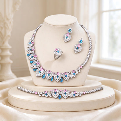 The Wren Wedding Suite - silver-tone teardrop-panel CZ statement necklace with rose-pink and azure-blue accents on an ivory bust, with earrings, bracelet and ring