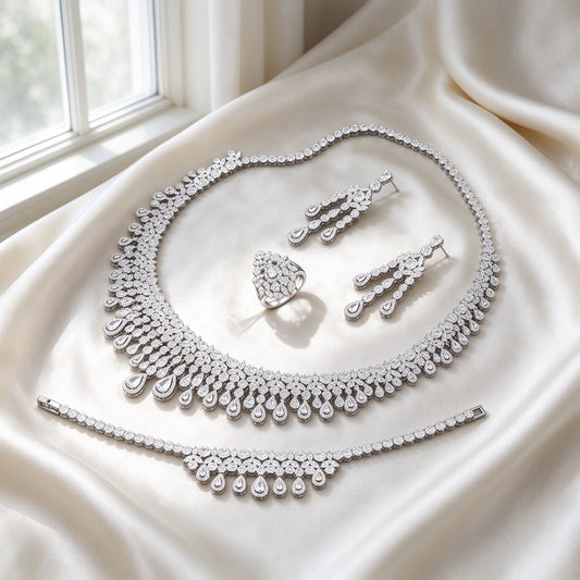 The Moonlight Bridal Set silver-tone pavé collar necklace with graduating pear-cut teardrop fringe, drop earrings, tennis bracelet and pear-cluster ring on ivory silk