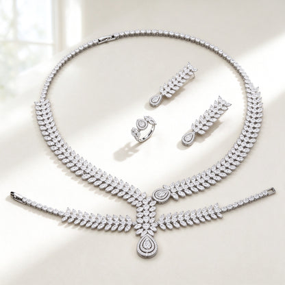 The Cordelia Wedding Suite — silver-tone graduated marquise-leaf pavé collar necklace with double-halo pear pendant, leaf-drop earrings, bracelet and ring on an ivory background