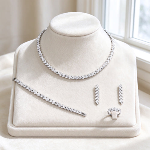 The Thorn Wedding Suite — silver-tone marquise-leaf vine collarette necklace, matching bracelet, linear drop earrings and leaf-band ring fully paved with clear cubic zirconia on ivory velvet